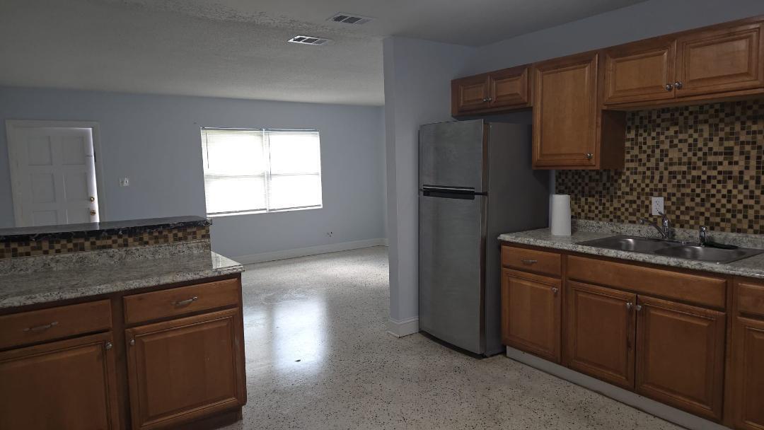 2736 Seneca Avenue Fort Pierce, FL 34946 - Photo 16 of 16 a kitchen with a refrigerator and cabinets