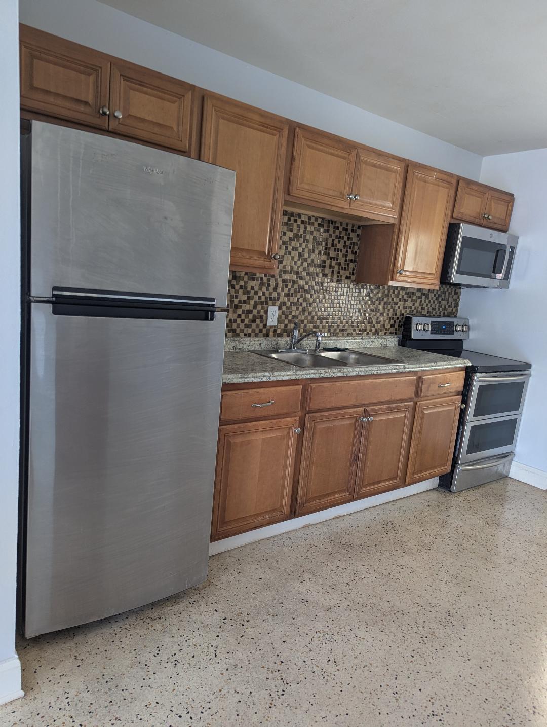 2736 Seneca Avenue Fort Pierce, FL 34946 - Photo 8 of 16 a kitchen with stainless steel appliances granite countertop a refrigerator sink and cabinets