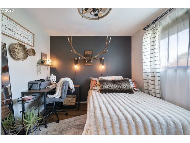 a bedroom with a bed and a lamp on dresser