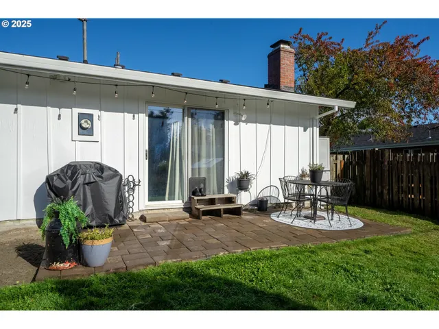 a view of a patio with table and chairs with wooden fence