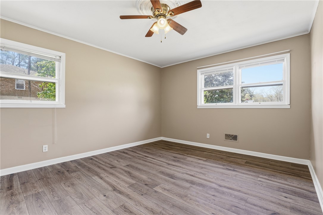 4304 Old Buncombe Road Greenville, SC 29617 - Photo 15 of 50 This airy bedroom offers ample natural light and durable flooring, creating a comfortable living space.
