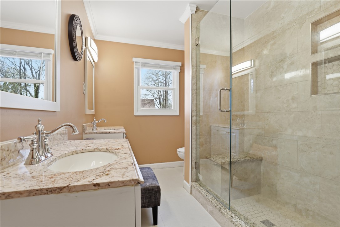 4304 Old Buncombe Road Greenville, SC 29617 - Photo 17 of 50 This bright bathroom features dual vanities and a spacious walk-in shower with elegant tile work.