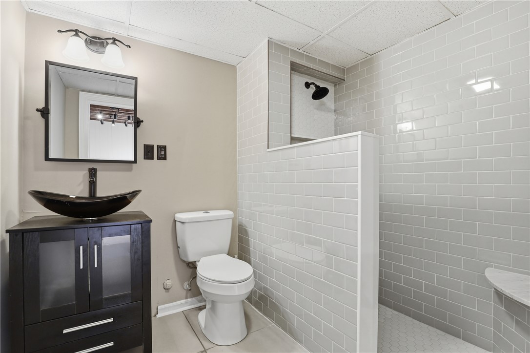 4304 Old Buncombe Road Greenville, SC 29617 - Photo 31 of 50 This bathroom features sleek tile and a modern vanity, offering a clean and functional design.