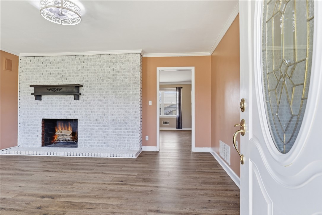 4304 Old Buncombe Road Greenville, SC 29617 - Photo 4 of 50 This inviting interior features a brick fireplace, rich hardwood flooring, and crown molding.