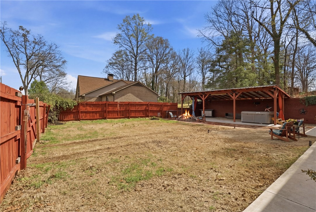 4304 Old Buncombe Road Greenville, SC 29617 - Photo 41 of 50 This spacious yard features a covered patio with a hot tub and fire pit.