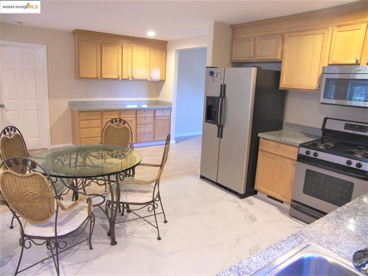 1259 Fulton Avenue Vallejo, CA 94591 - Photo 14 of 28 a kitchen with stainless steel appliances kitchen island granite countertop a table and chairs