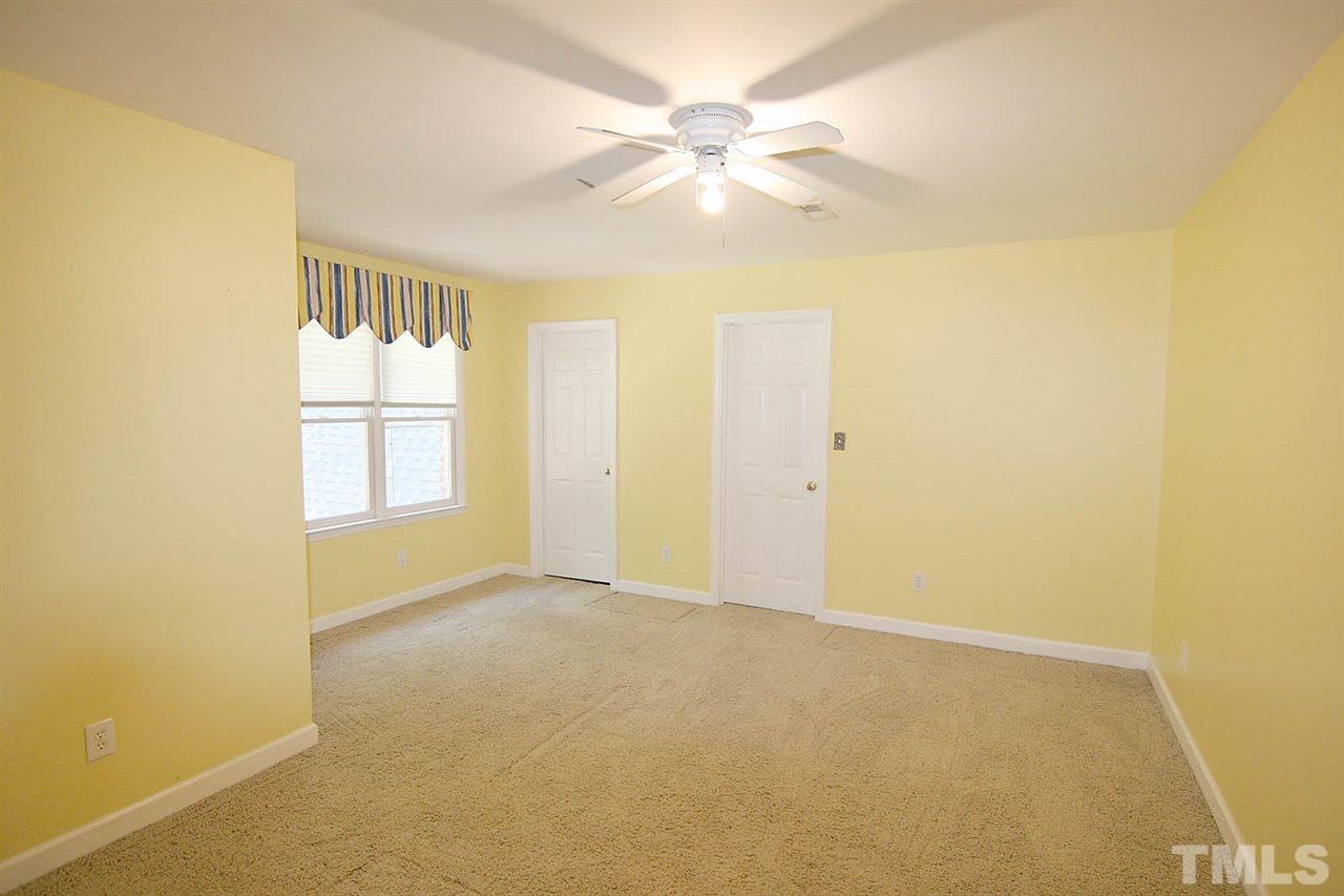 218 Queensferry Road Cary, NC 27511 - Photo 18 of 25 an empty room with windows and chandelier fan