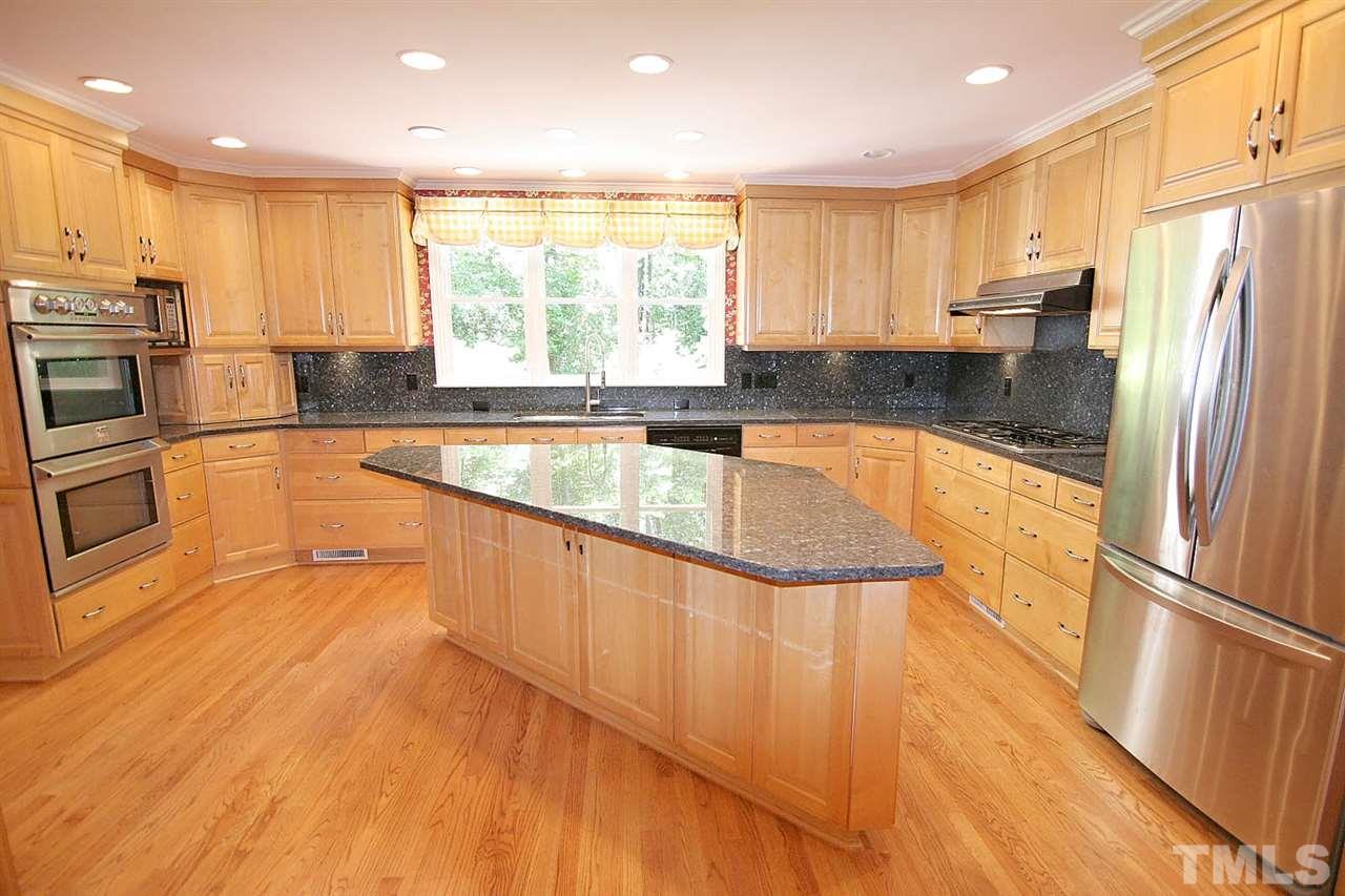 218 Queensferry Road Cary, NC 27511 - Photo 7 of 25 a large kitchen with granite countertop a large counter top stainless steel appliances and cabinets