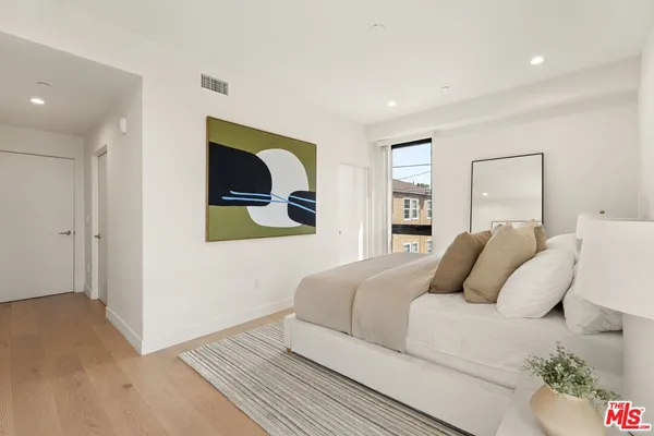 a bedroom with a bed and a painting on the wall