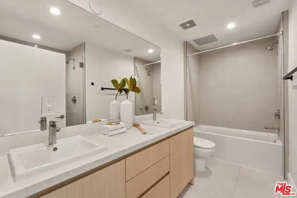 a bathroom with a granite countertop sink a toilet and shower
