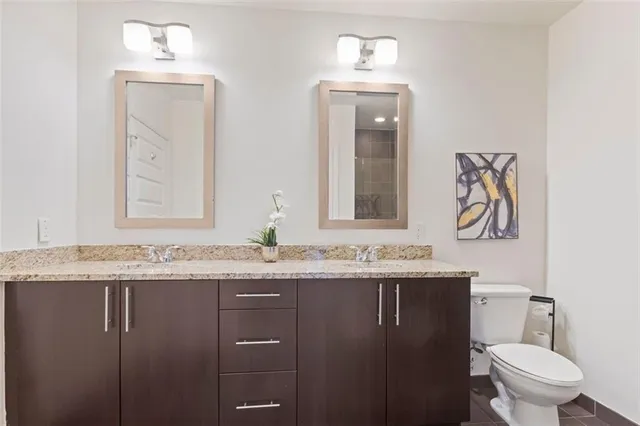 a bathroom with a granite countertop sink toilet and shower
