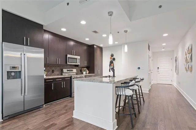 a kitchen with kitchen island white cabinets and stainless steel appliances