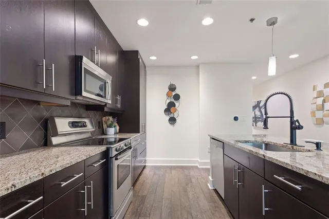 a kitchen with granite countertop stainless steel appliances and wooden floor