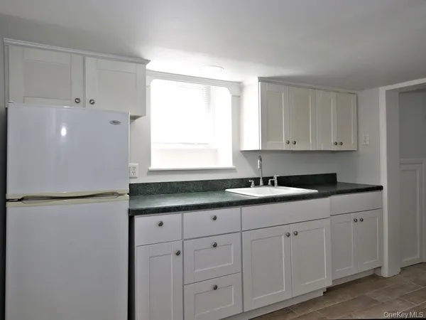 a kitchen with white cabinets and white appliances