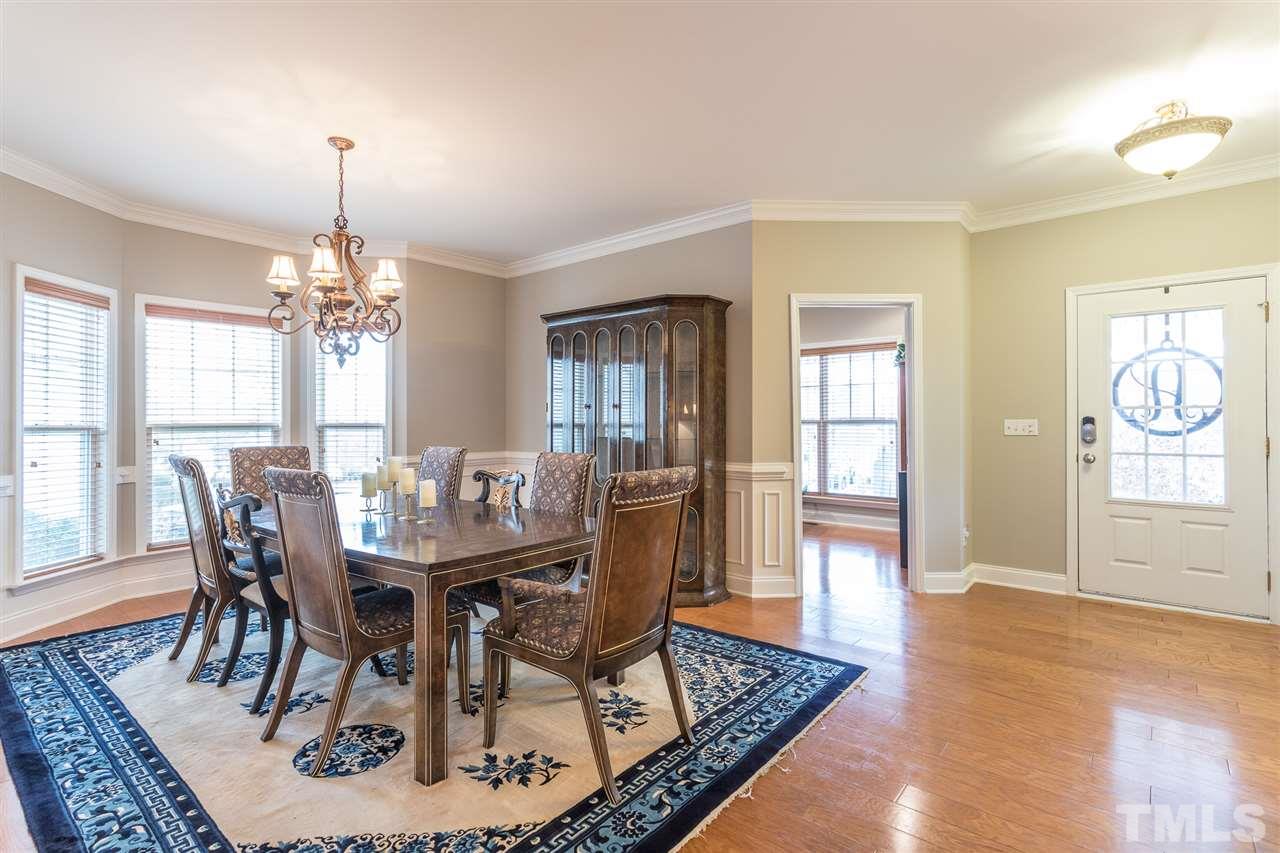 107 Locke Woods Road Raleigh, NC 27603 - Photo 12 of 30 a dining room with furniture a rug and wooden floor
