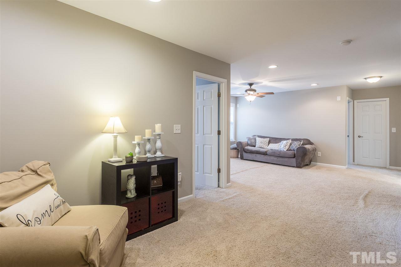 107 Locke Woods Road Raleigh, NC 27603 - Photo 22 of 30 a living room with furniture and a chandelier