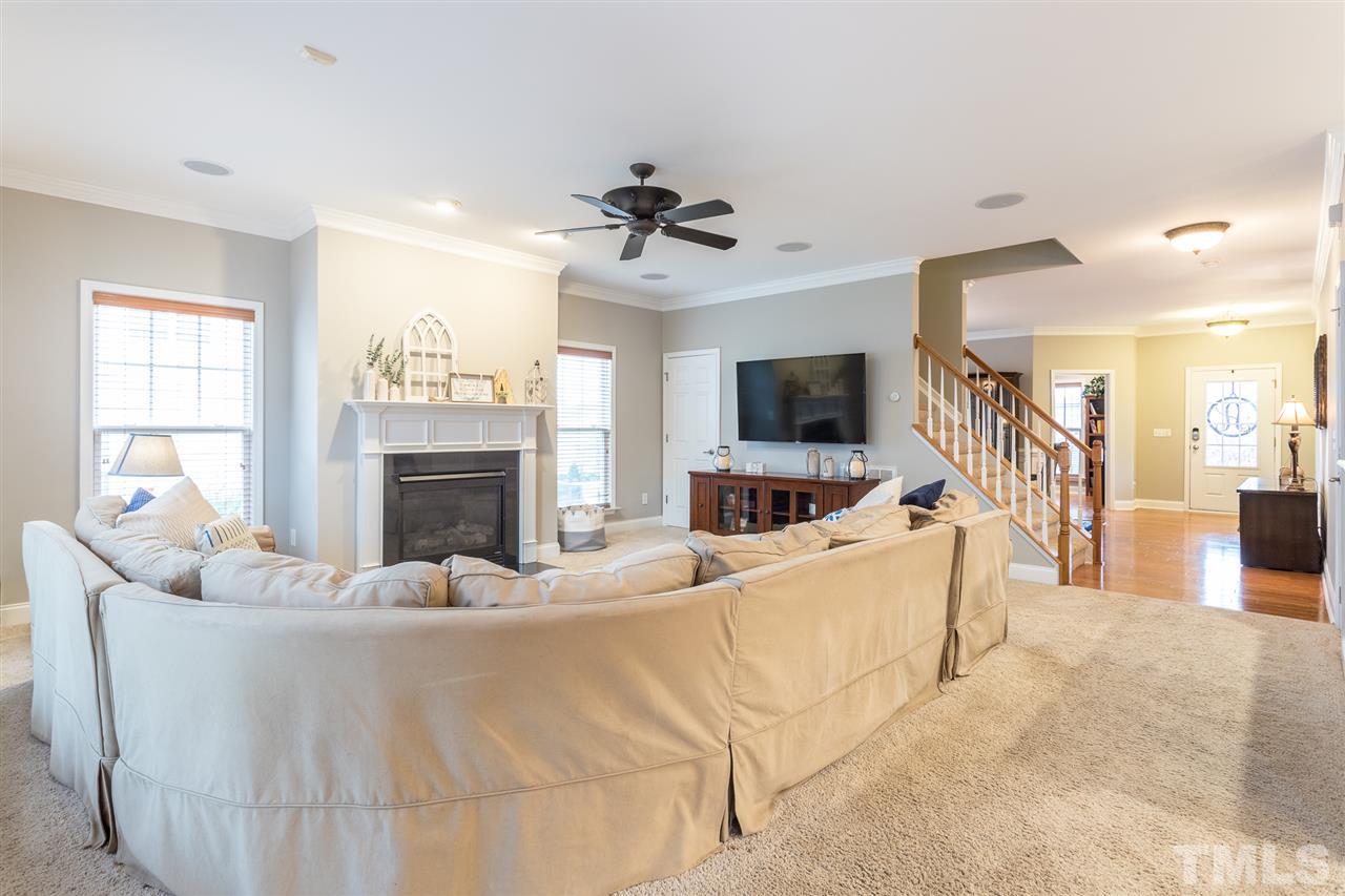 107 Locke Woods Road Raleigh, NC 27603 - Photo 5 of 30 a living room with furniture a flat screen tv and a fireplace