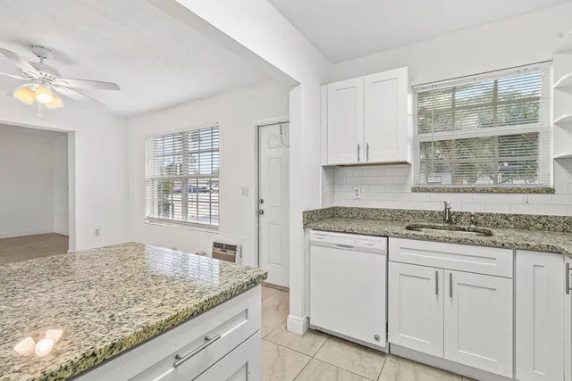 a kitchen with granite countertop cabinets and window