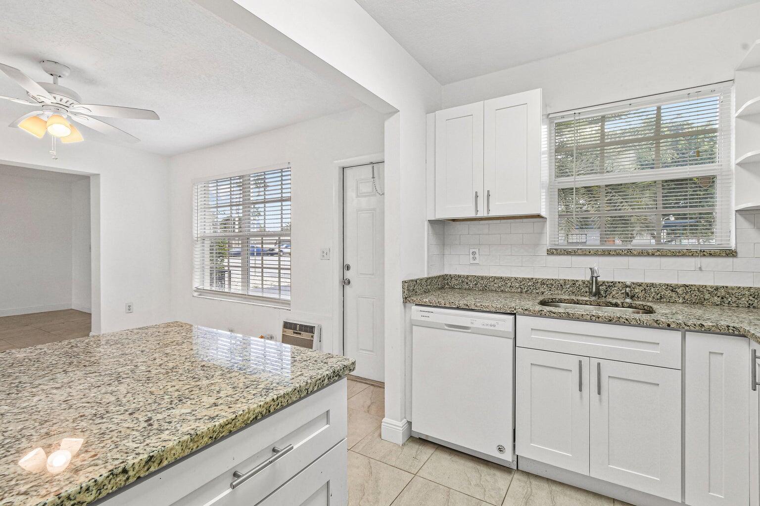 101 Akron Street, Unit 101 Lake Worth Beach, FL 33461 - Photo 6 of 11 a kitchen with granite countertop cabinets and window