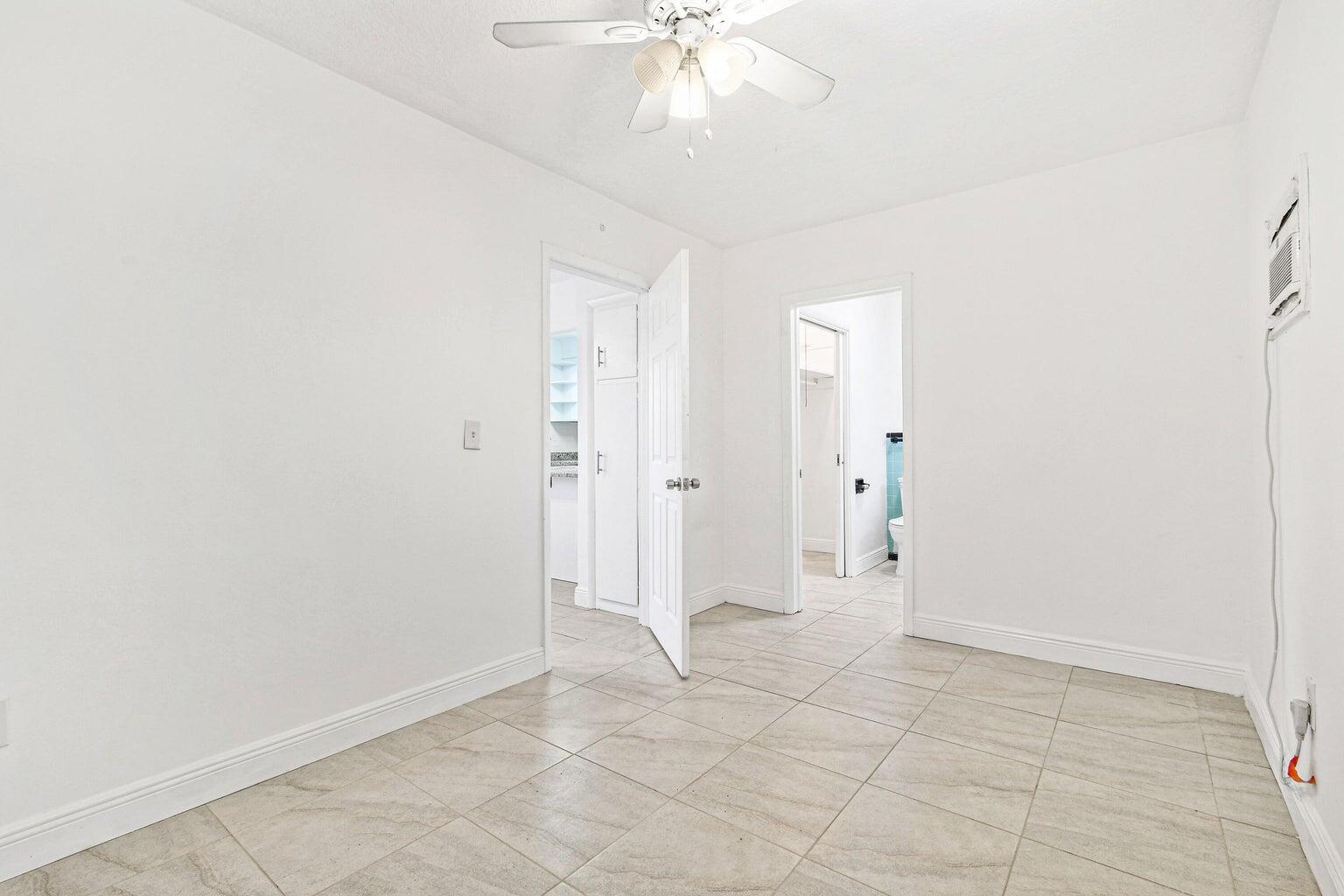 101 Akron Street, Unit 101 Lake Worth Beach, FL 33461 - Photo 8 of 11 an empty room with fan and entrance