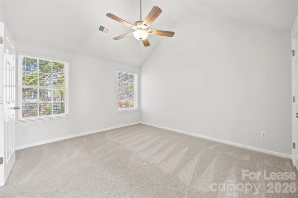 an empty room with a window and a fan
