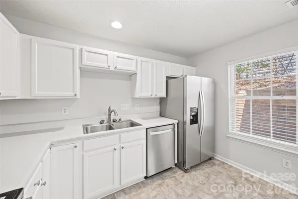 a kitchen with a sink cabinets and a window