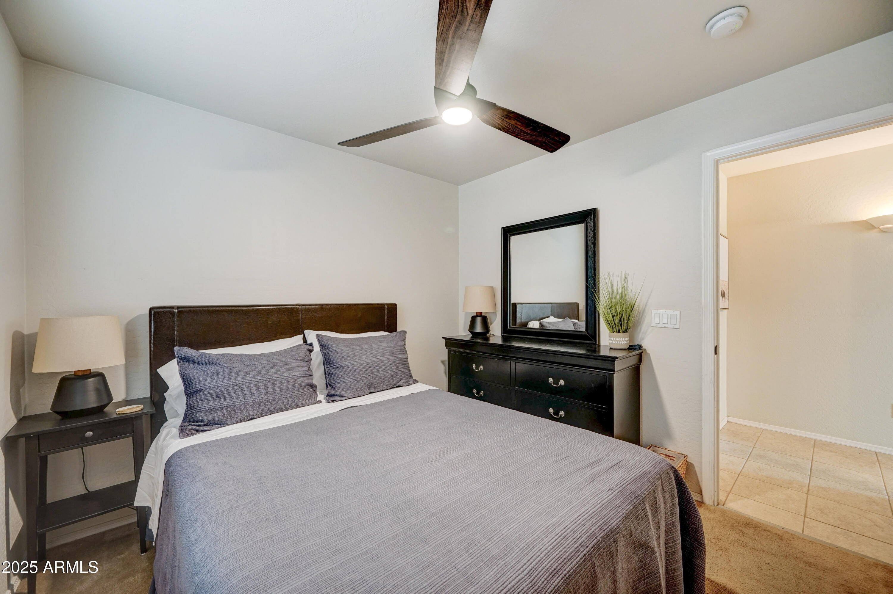 Undisclosed Address San Tan Valley, AZ 85143 - Photo 18 of 57 a bedroom with a bed and a lamp on dresser