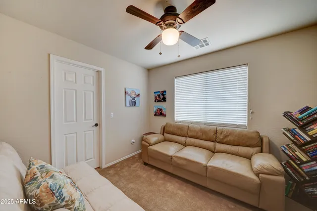 a living room with patio furniture and a potted plants
