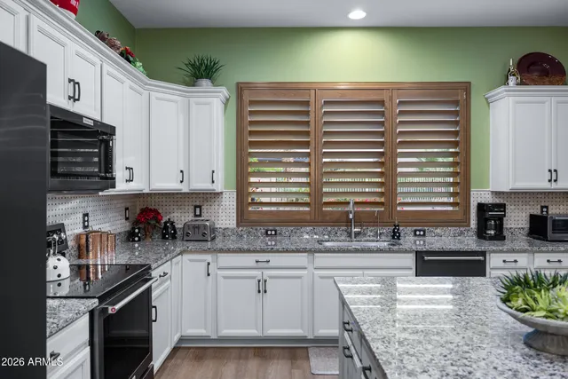 a kitchen with stainless steel appliances granite countertop a sink and cabinets