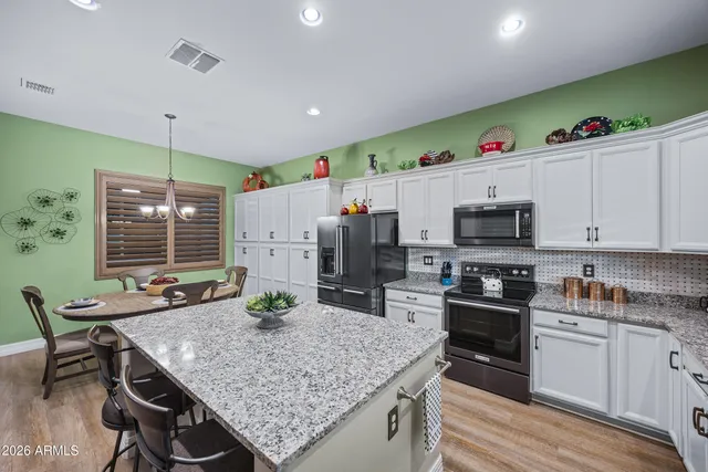 a kitchen with stainless steel appliances granite countertop a stove refrigerator sink and cabinets