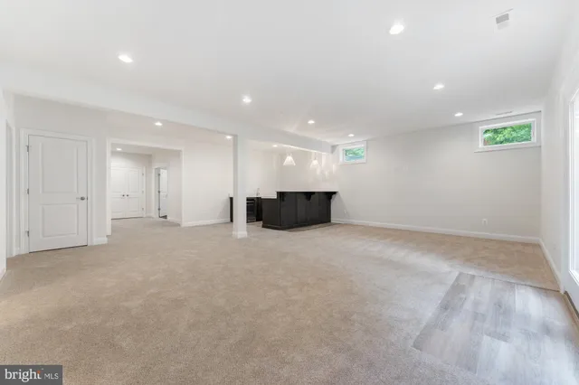 a view of a big room with a chandelier fan and windows