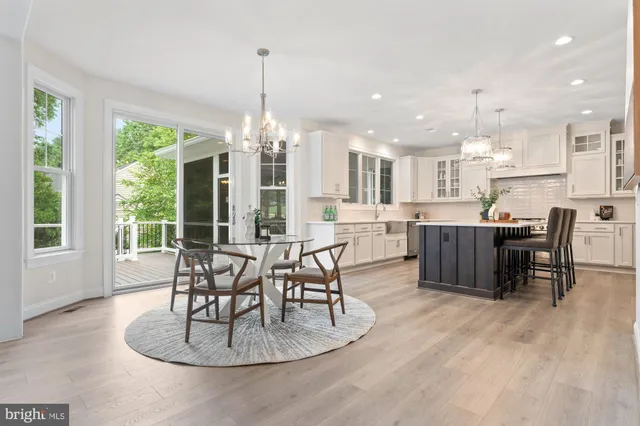 a dining room with furniture a chandelier and kitchen view