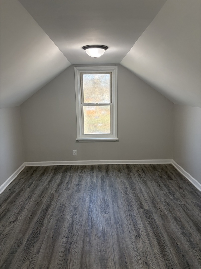 621 Mohawk Street Joliet, IL 60432 - Photo 13 of 15 an empty room with wooden floor and windows