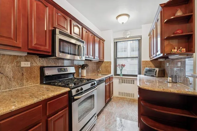 a kitchen with stainless steel appliances granite countertop a stove and cabinets