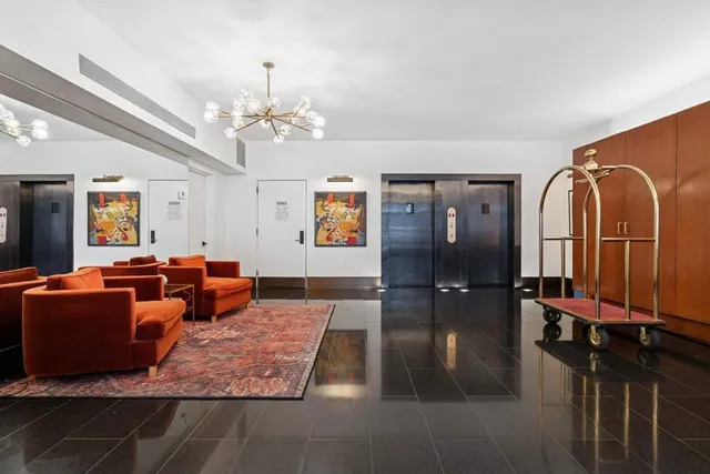 a living room with furniture a chandelier and a flat screen tv