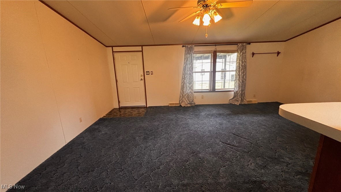2090 Big Flint Road Salem, WV 26426 - Photo 13 of 22 Empty room with dark colored carpet, a ceiling fan, and crown molding