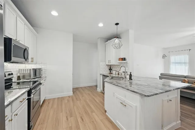 a kitchen with stainless steel appliances granite countertop a sink stove and refrigerator
