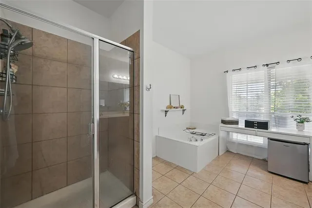 a large white bathroom with a bathtub sink a toilet a mirror and shower