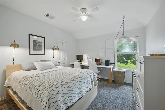 a bedroom with a bed a window and a chandelier