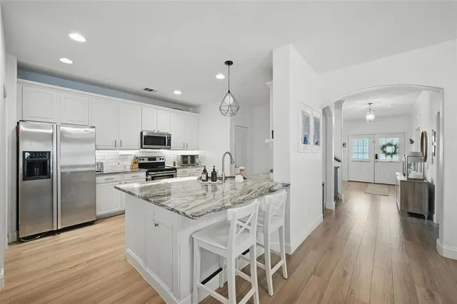 a kitchen with stainless steel appliances granite countertop a sink stove and refrigerator