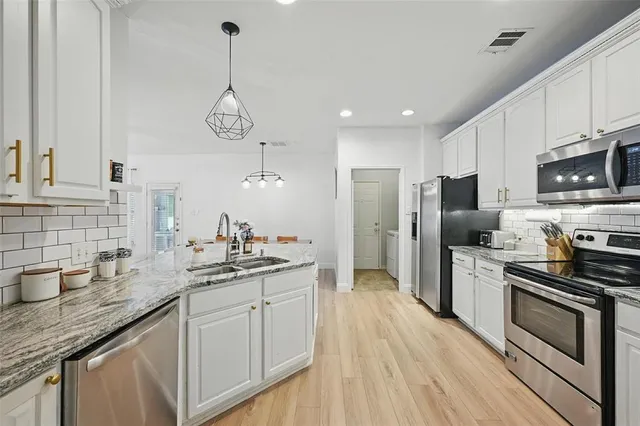 a kitchen with stainless steel appliances a sink stove and refrigerator
