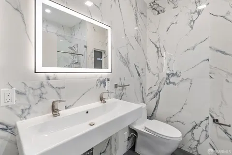 a bathroom with a sink mirror and toilet