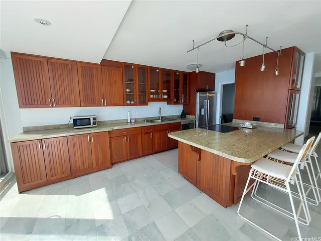 a kitchen with stainless steel appliances granite countertop a stove a sink and a microwave