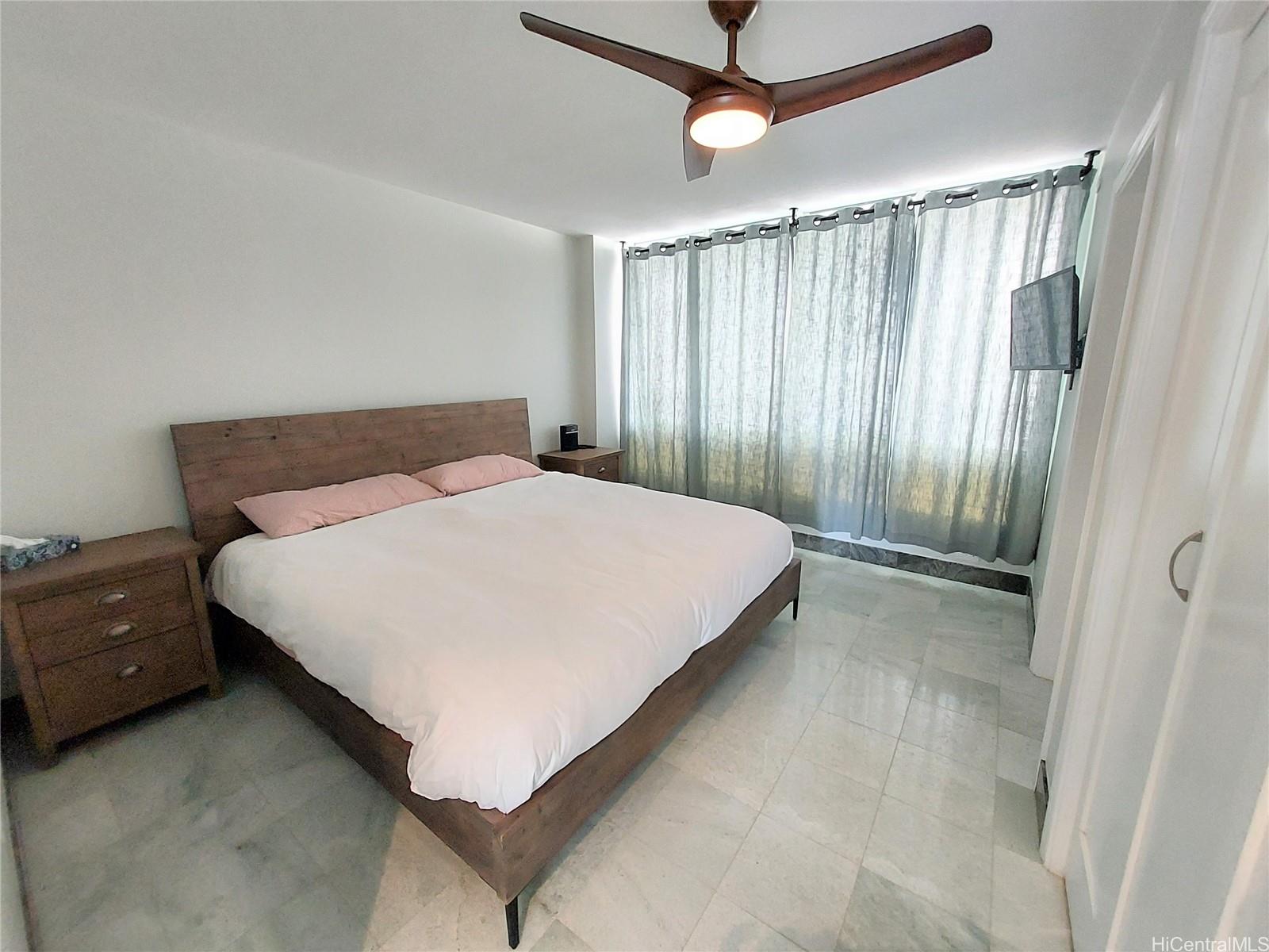 2801 Coconut Avenue, Unit 6B Honolulu, HI 96815 - Photo 9 of 12 a bedroom with a bed and a chandelier