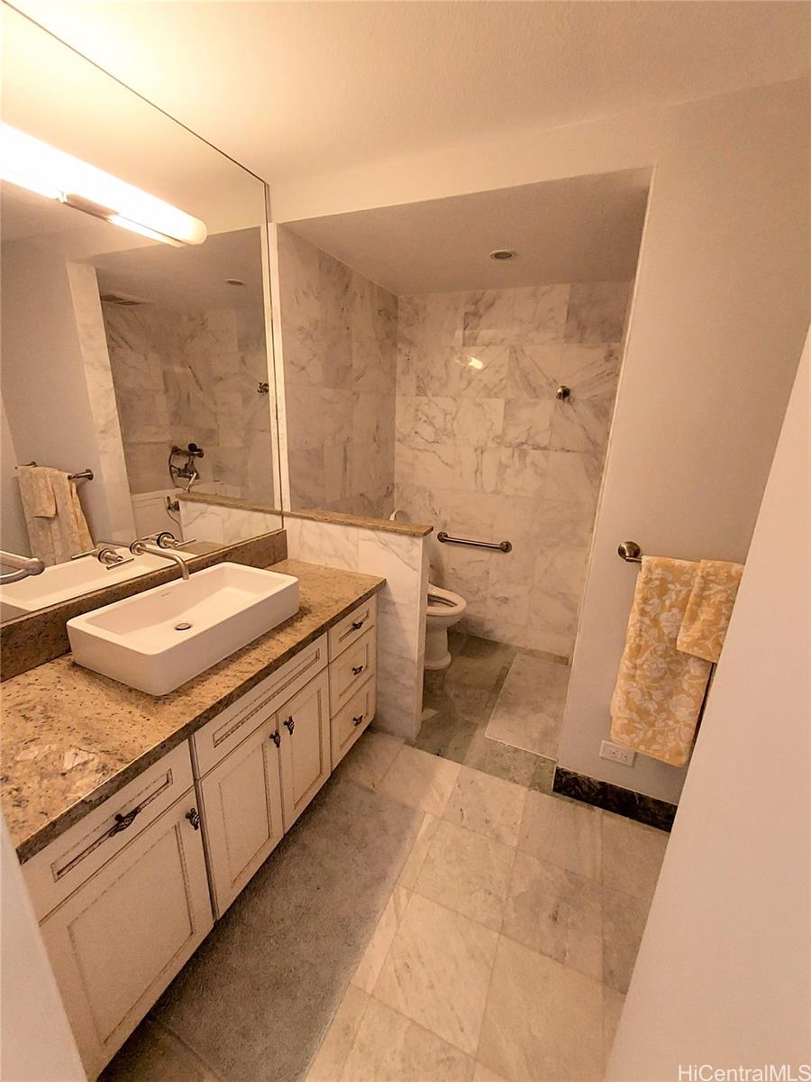 2801 Coconut Avenue, Unit 6B Honolulu, HI 96815 - Photo 10 of 12 a spacious bathroom with a granite countertop sink mirror and a toilet