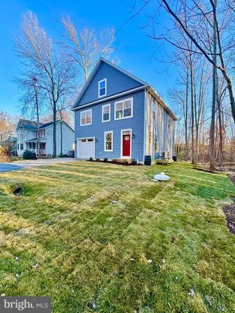 a big yard with large tree in front of it