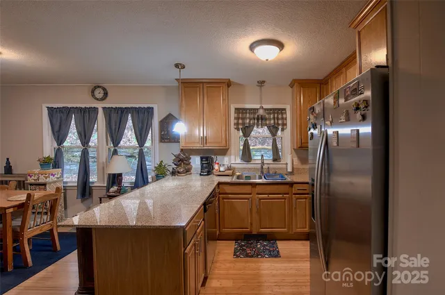 a kitchen with stainless steel appliances granite countertop a sink a stove and a refrigerator