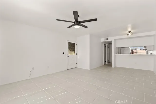a view of a livingroom with wooden floor and a ceiling fan