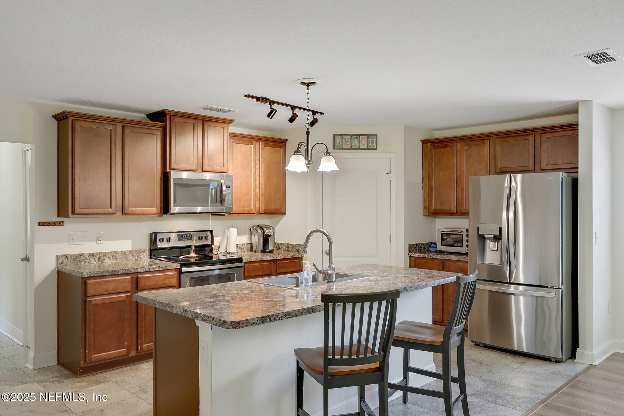 35 Root Lane St. Augustine, FL 32084 - Photo 16 of 37 a kitchen with stainless steel appliances granite countertop a dining table chairs refrigerator and sink