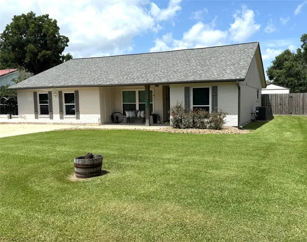 a front view of a house with a yard and trees